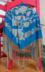Mantón Lumbre azul bordado con flores y flecos en beige